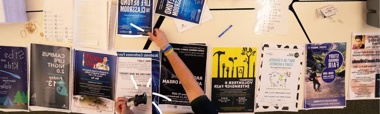 Student stamping posters to be posted on campus